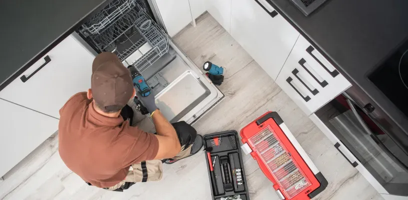 man-fixing-dishwasher-top-view